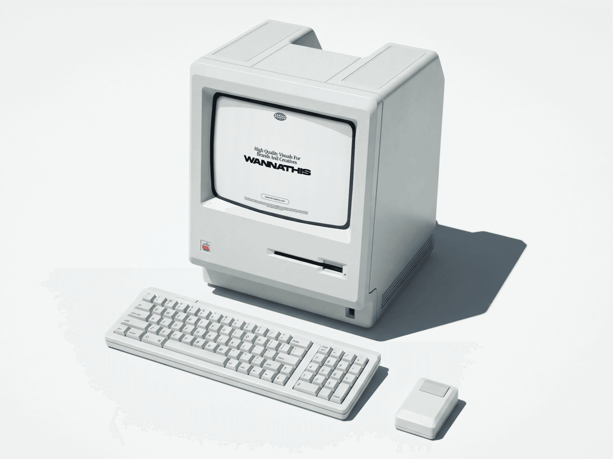 Boxy retro computer angled on a pale surface with a keyboard, mouse and hard shadow