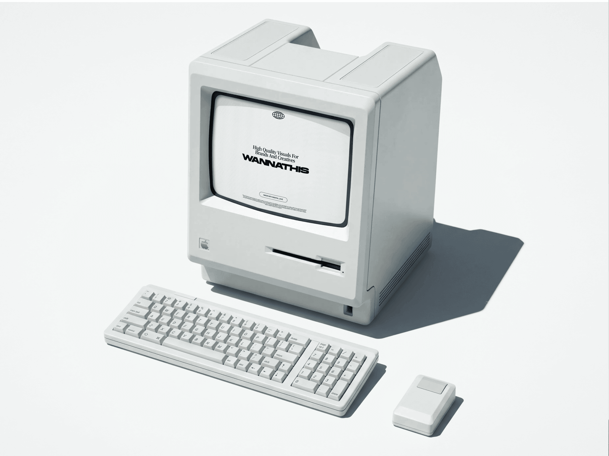 Boxy retro computer angled on a pale surface with a keyboard, mouse and hard shadow