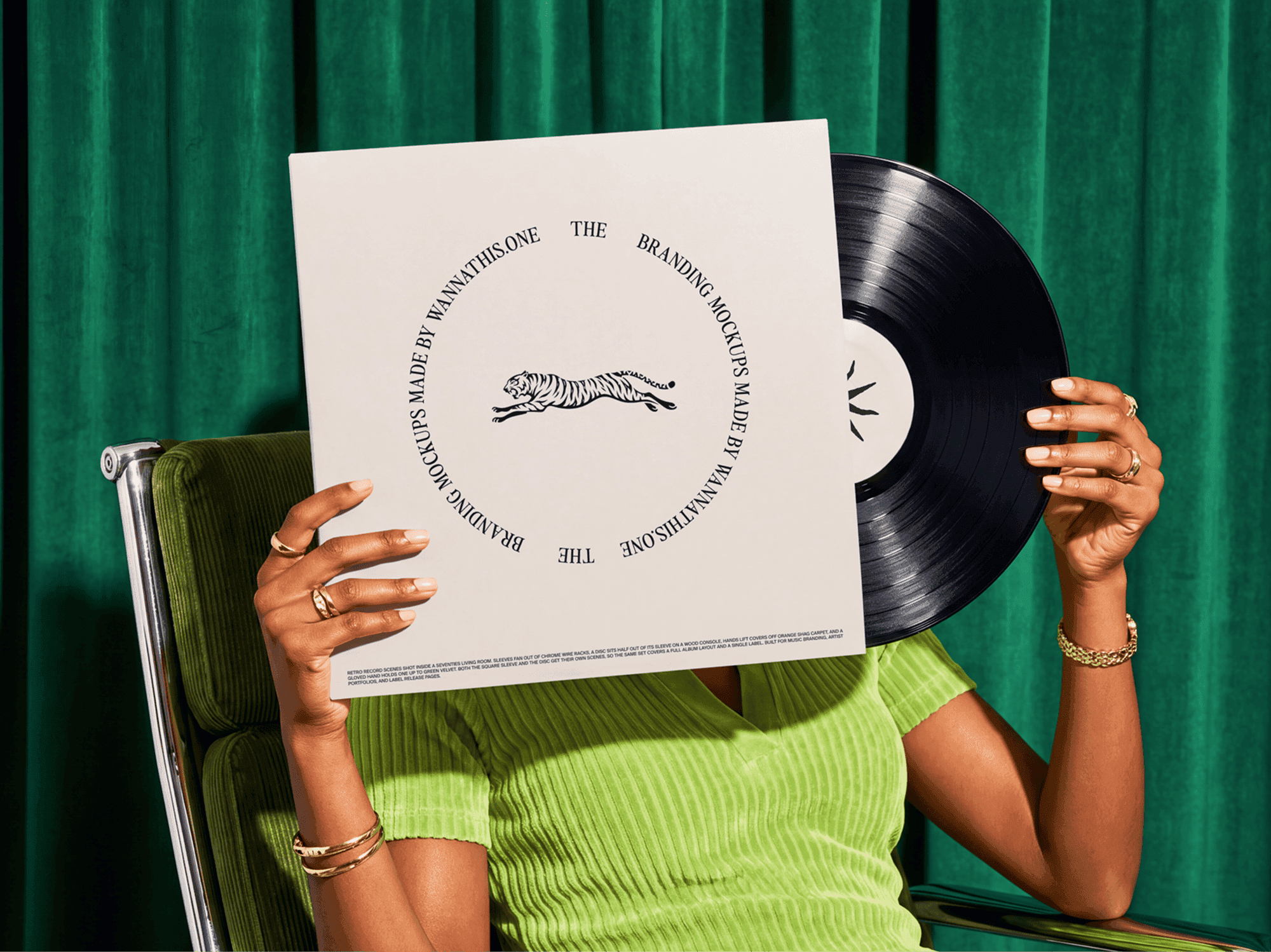 Person seated in a chair holding a vinyl record sleeve with the disc in the other hand