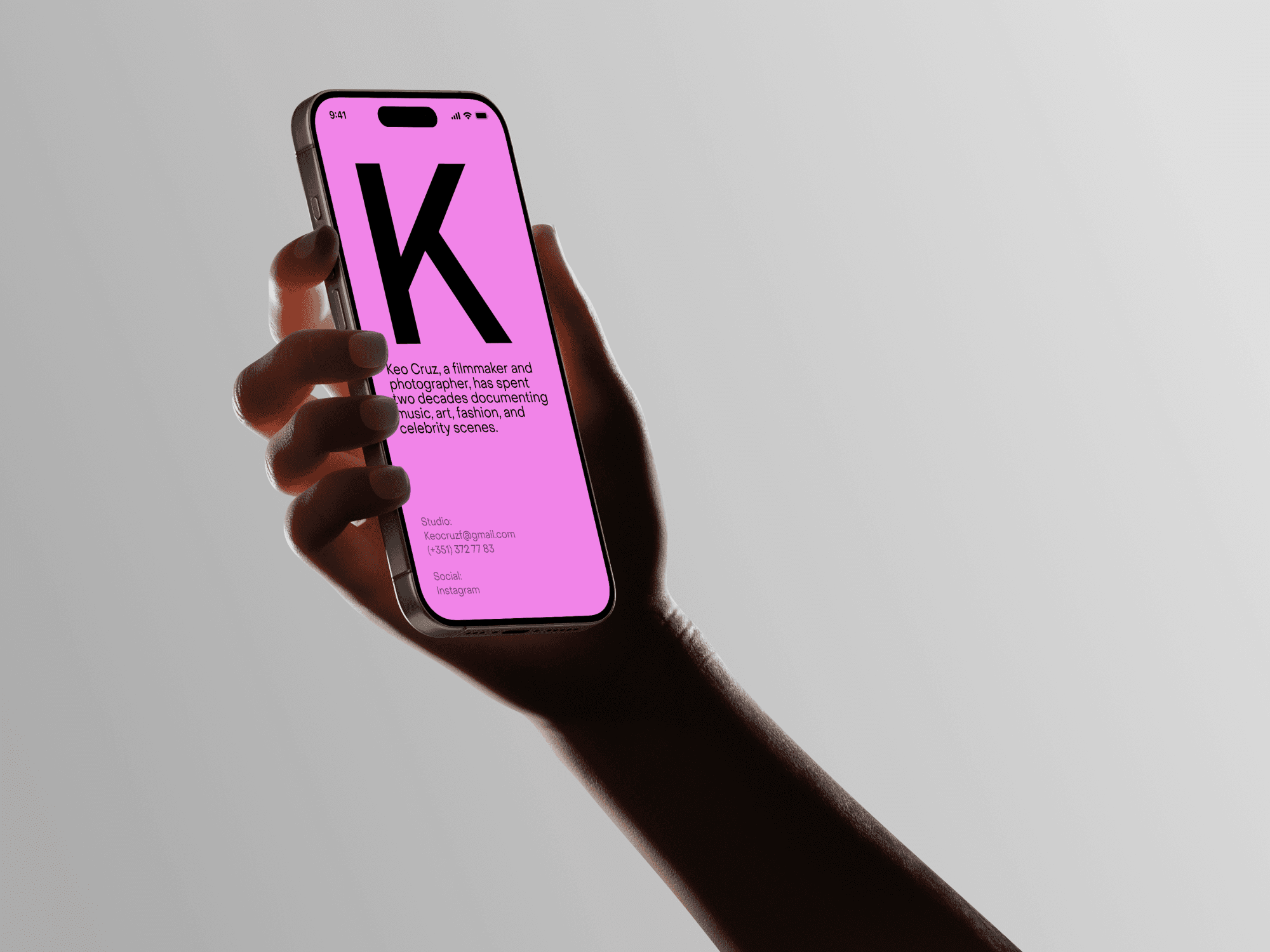 Hand holding an iPhone with a pink screen in a modern and elegant setup