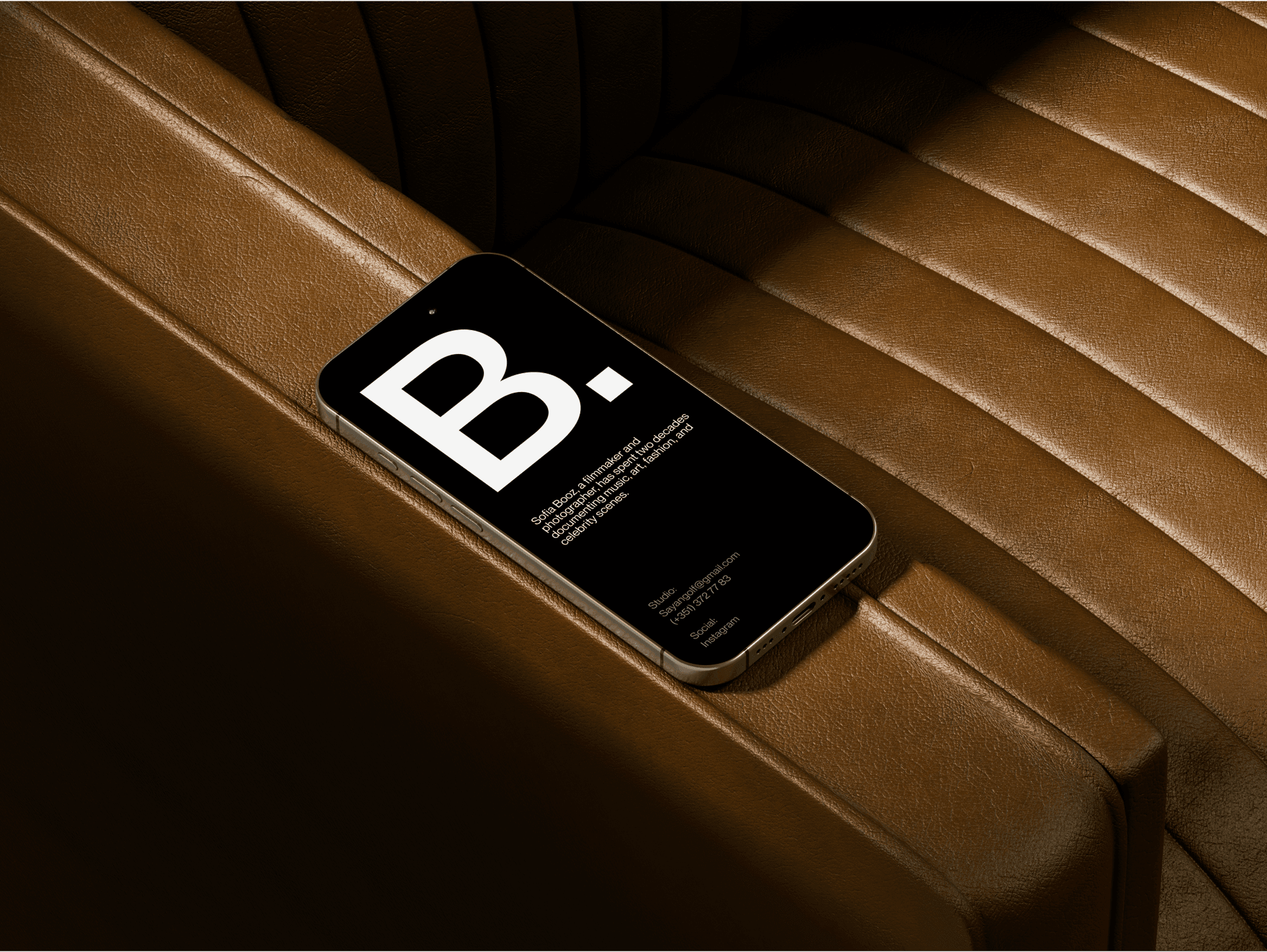 iPhone 16 mockup resting on the armrest of a brown leather chair.
