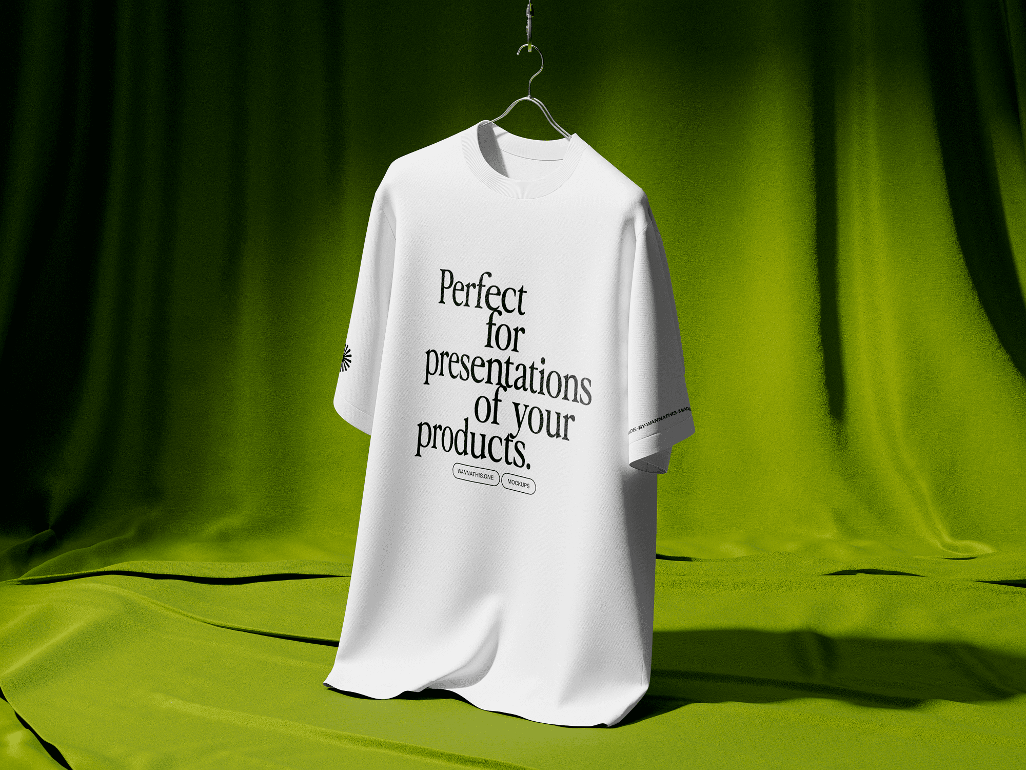 A white t-shirt mockup hanging in a green fabric environment with soft folds and shadows.