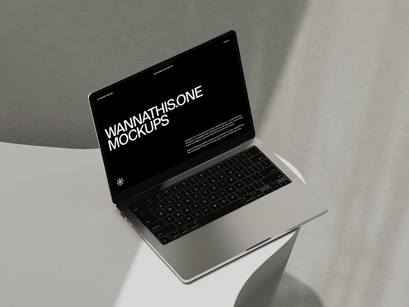 MacBook mockup angled on sculptural white stand in a beige room