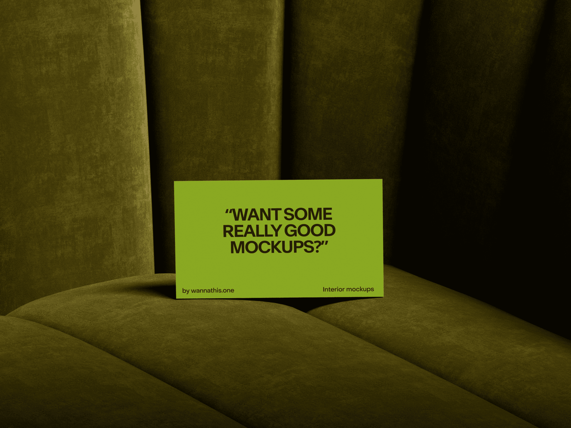 Business card mockup resting on a stylish green velvet couch.