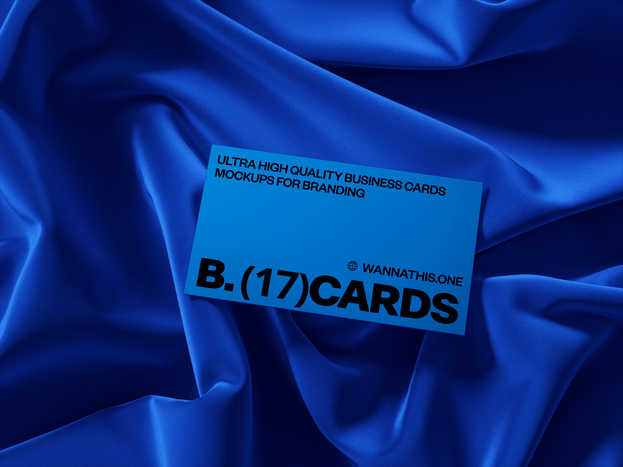 Blue business card mockup on a silky fabric background.