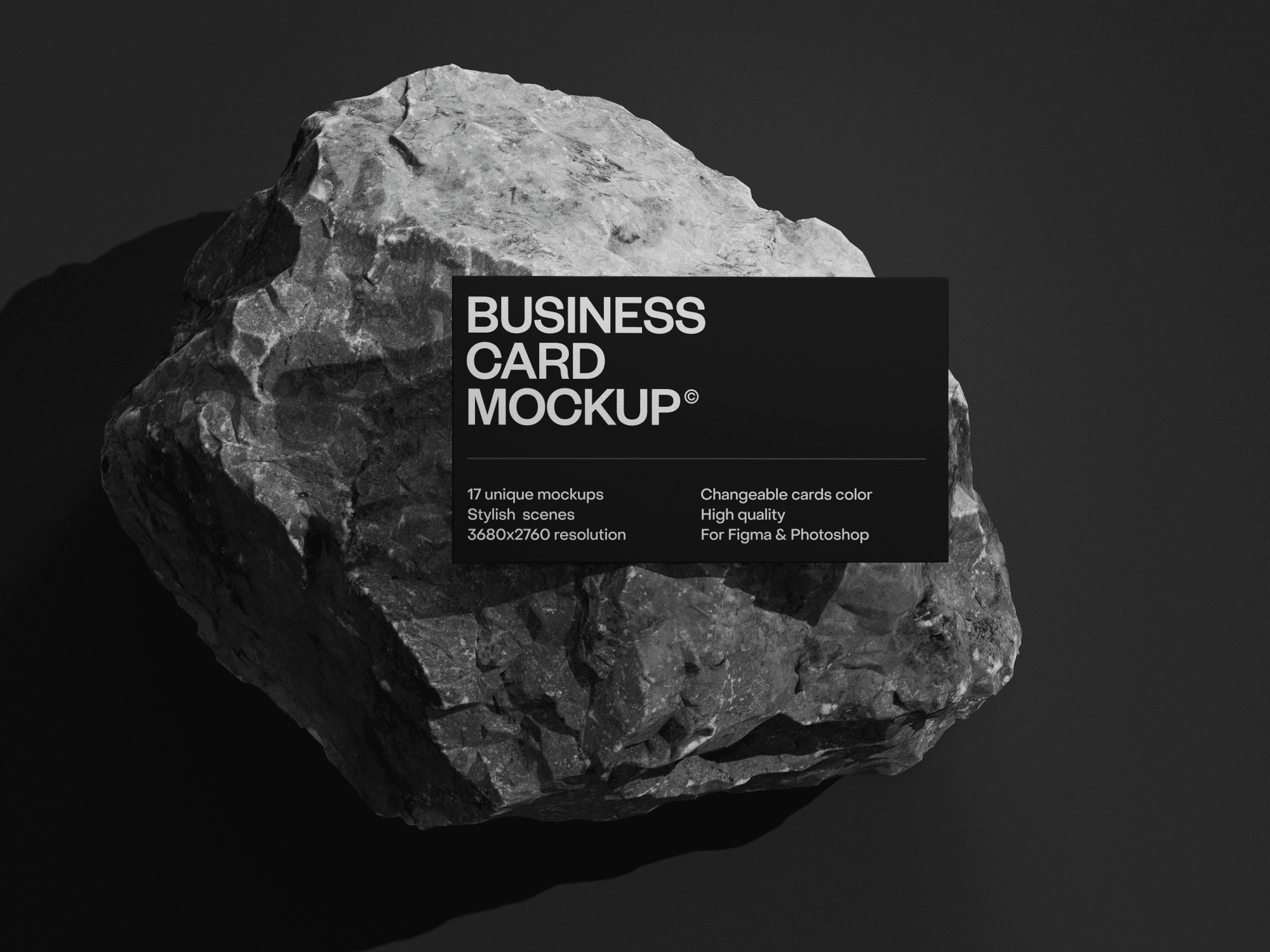 Black business card mockup placed on a rugged rock surface.