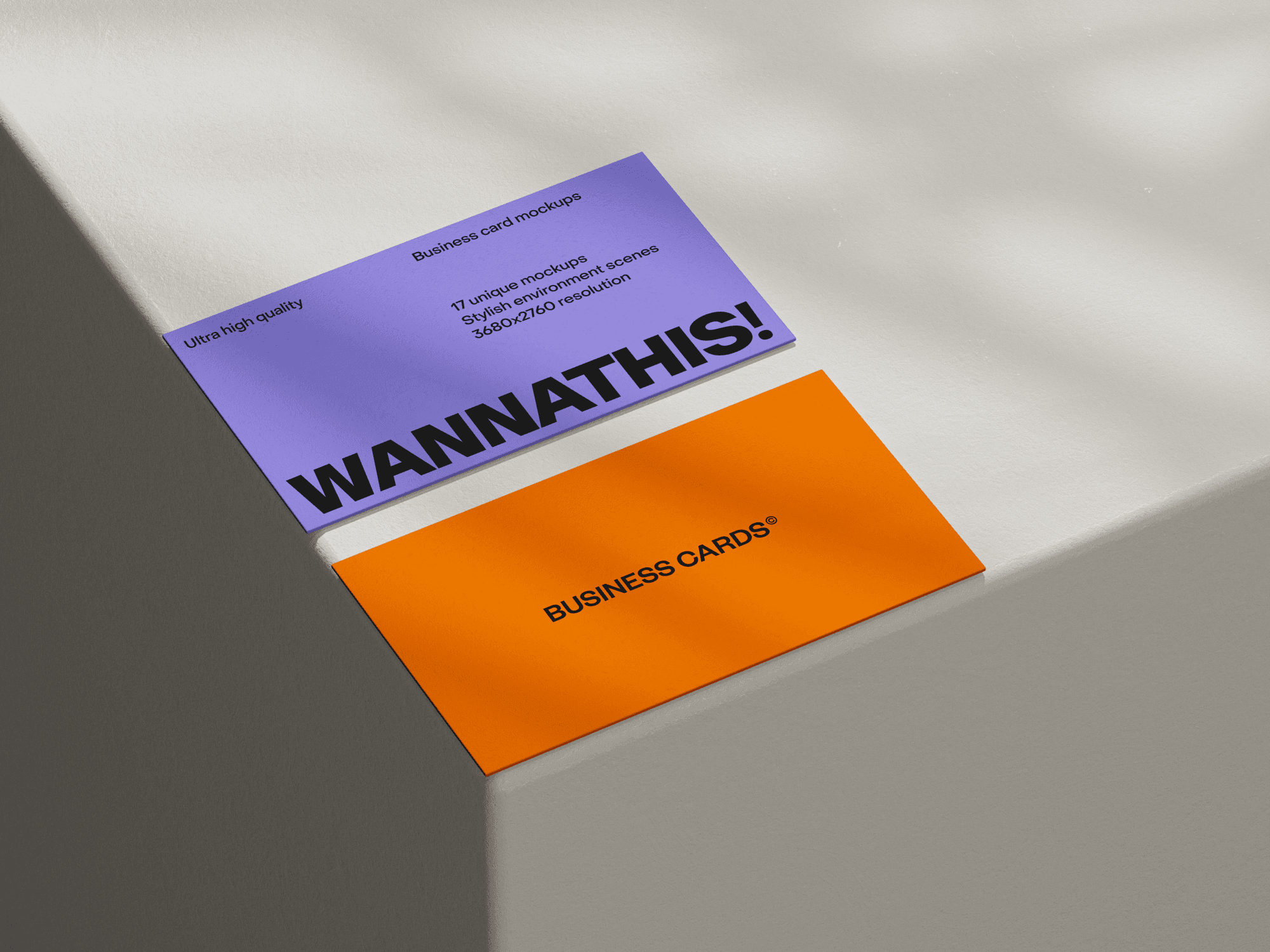 Two business cards placed on an illuminated white surface.