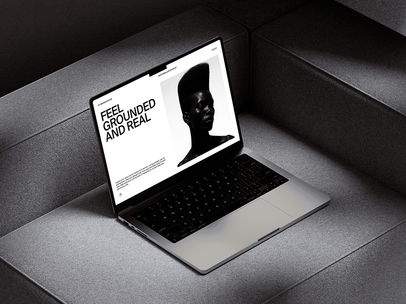 MacBook mockup positioned on a plush light grey couch