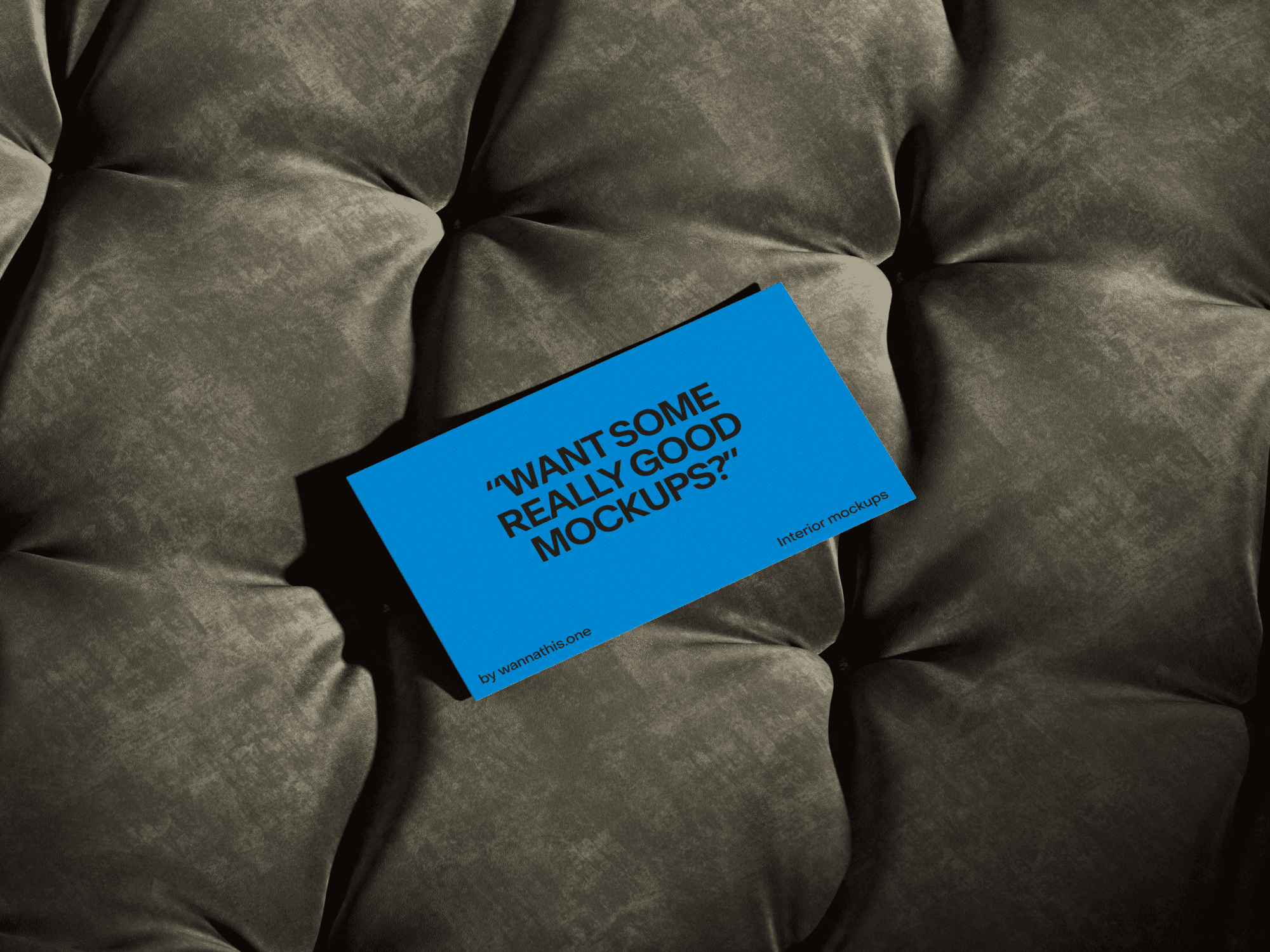 Blue business card mockup placed on a cushioned surface with deep textures.