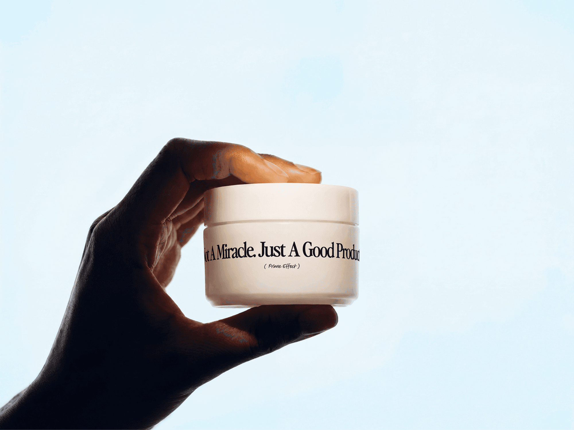 Hand holding a skincare cream jar mockup against a clean refined background in a minimal beauty studio scene
