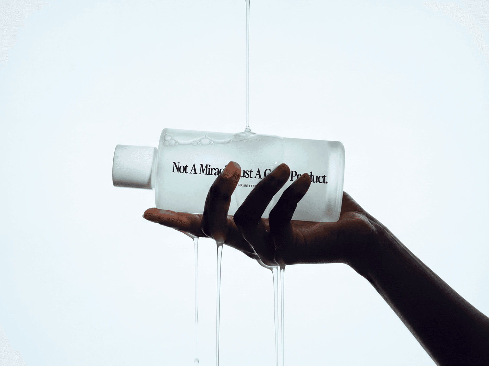 Hand holding a skincare lotion bottle mockup with flowing liquid in a refined minimal beauty studio scene