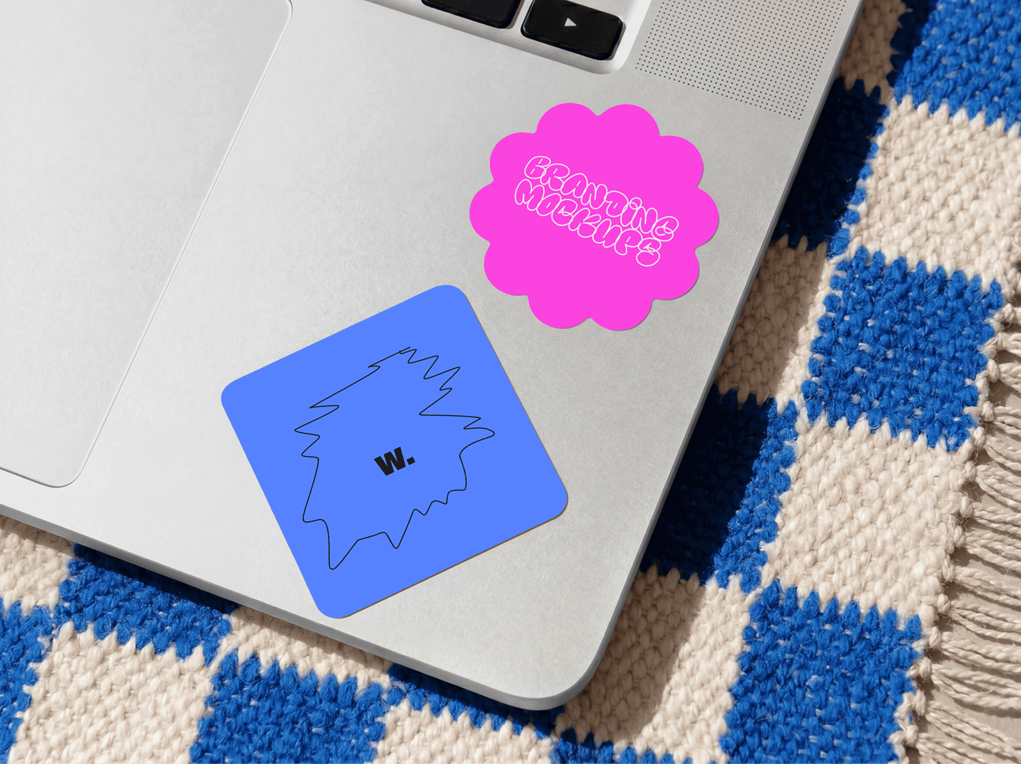 Multiple sticker mockups arranged on a laptop cover in a refined studio product showcase scene