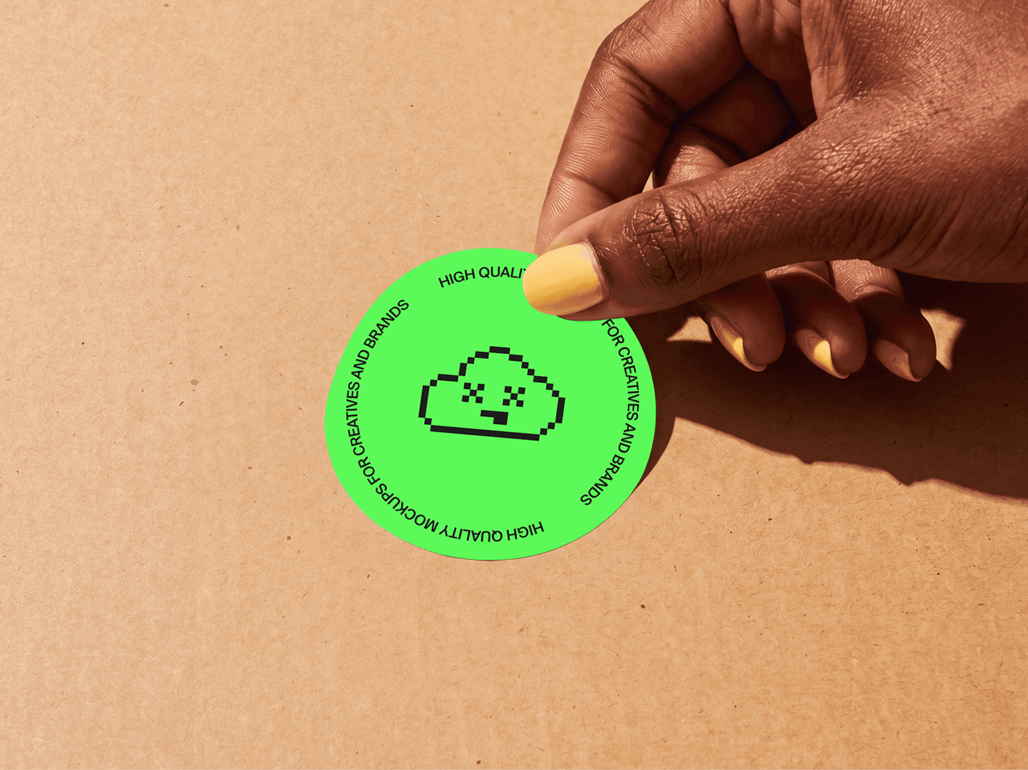 Round sticker mockup held up in a hand under natural directional light in a clean lifestyle scene