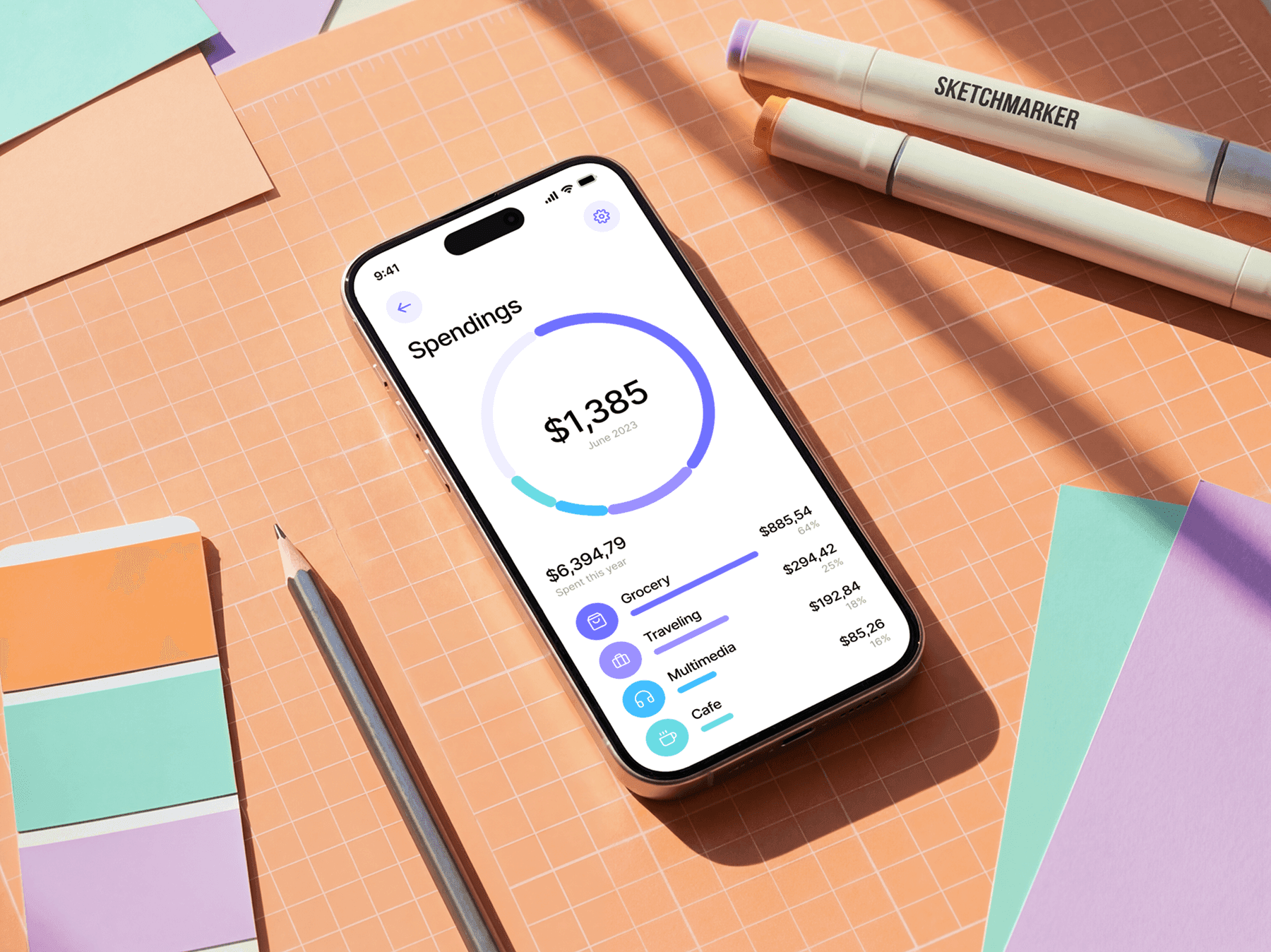 iPhone mockup placed on a cutting mat with stationery and design tools