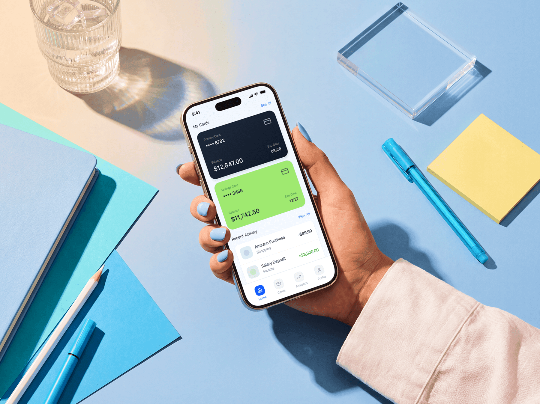 iPhone mockup held over a desk with office accessories and tools
