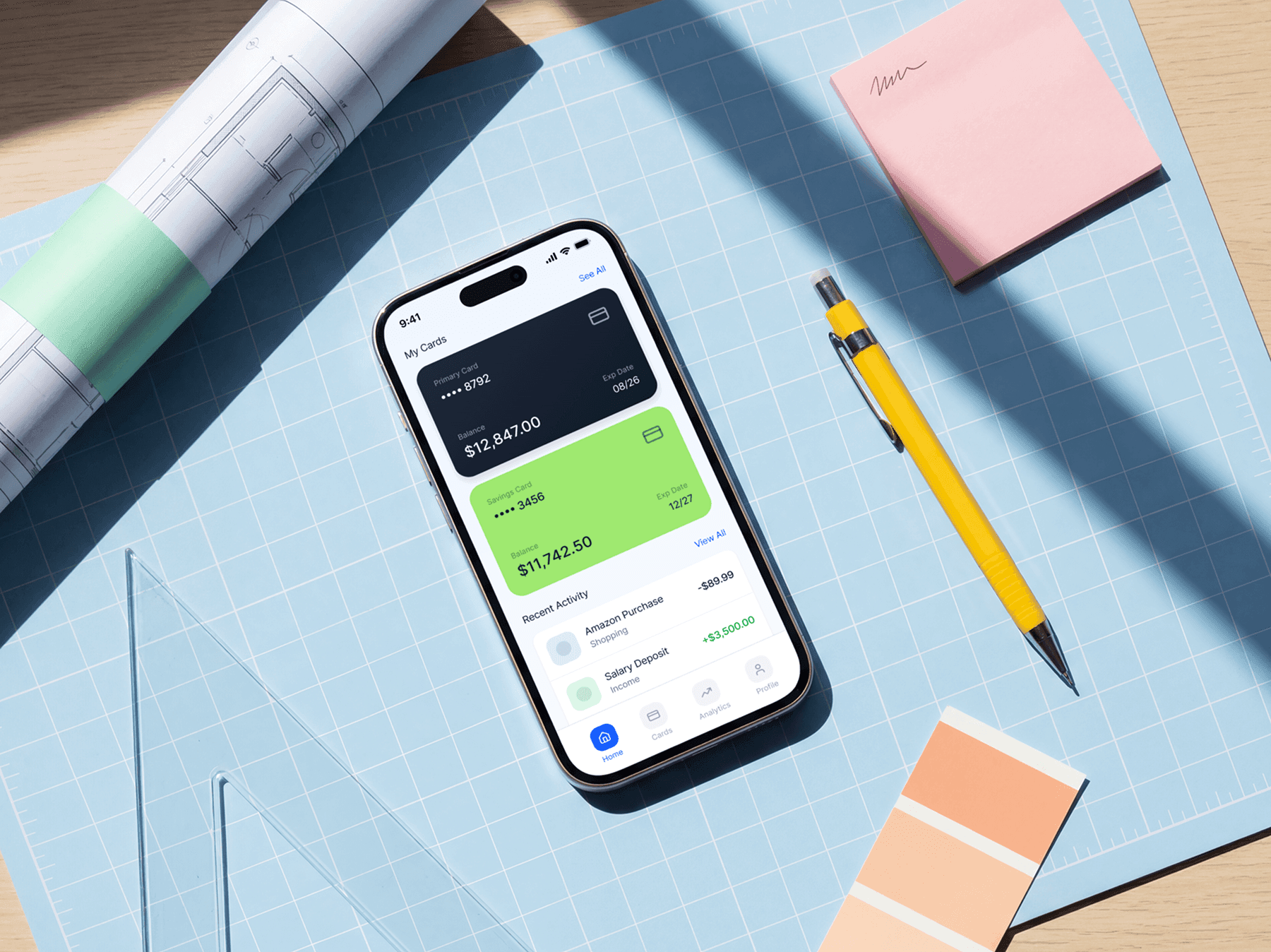 iPhone mockup placed on a cutting mat with design tools on a desk