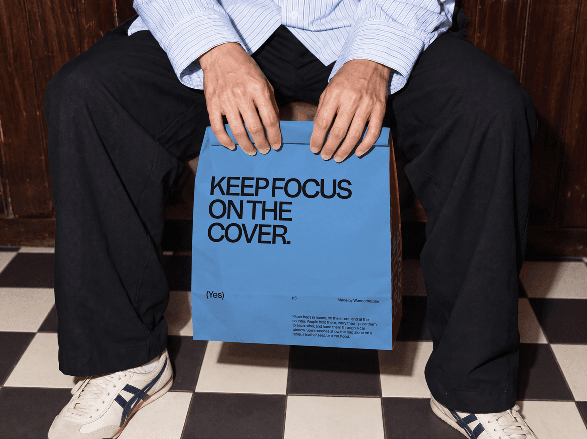 Paper shopping bag mockup resting between the knees of a person sitting down