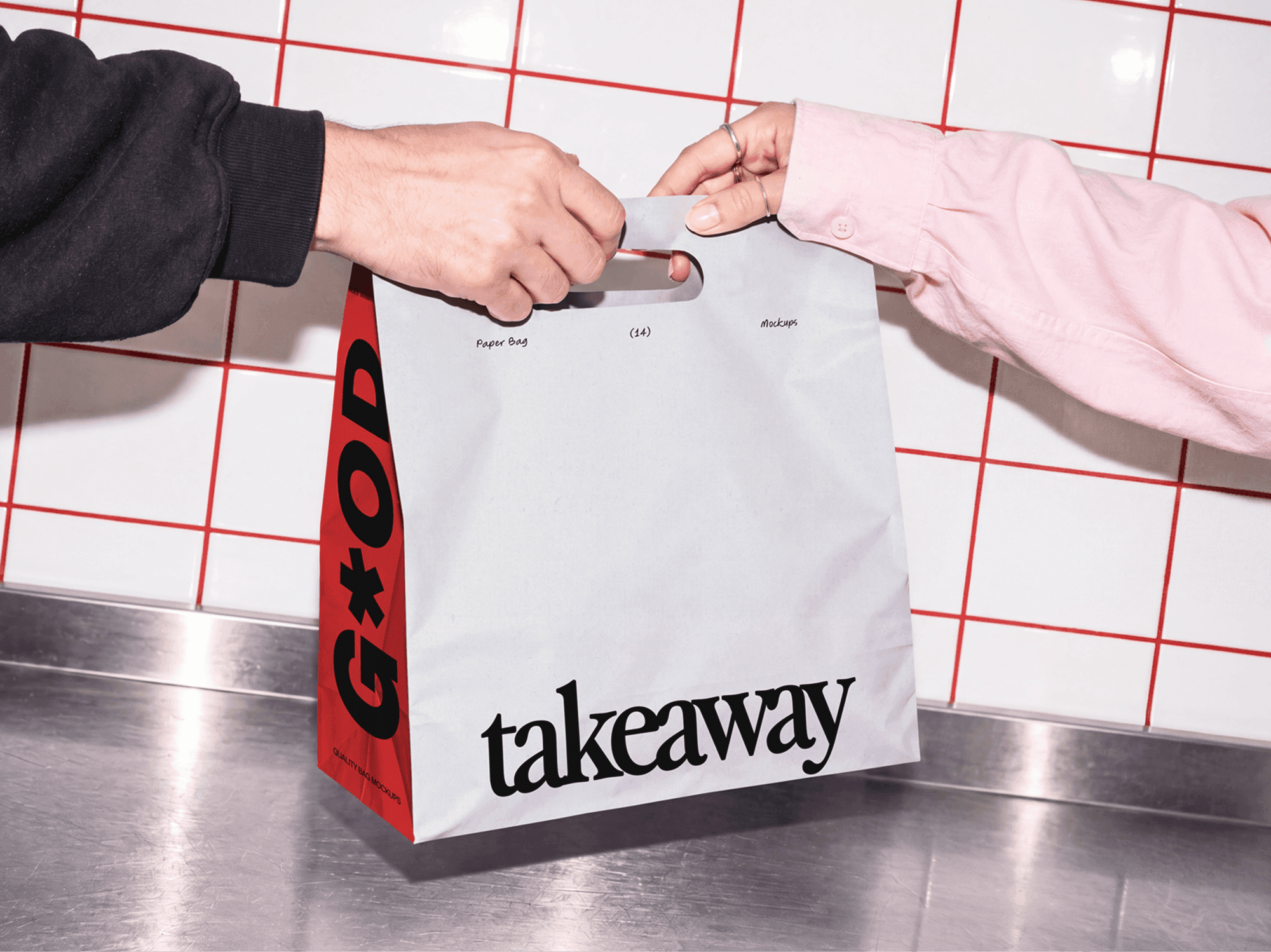 Takeaway paper bag mockup passing between two pairs of hands over a metal counter