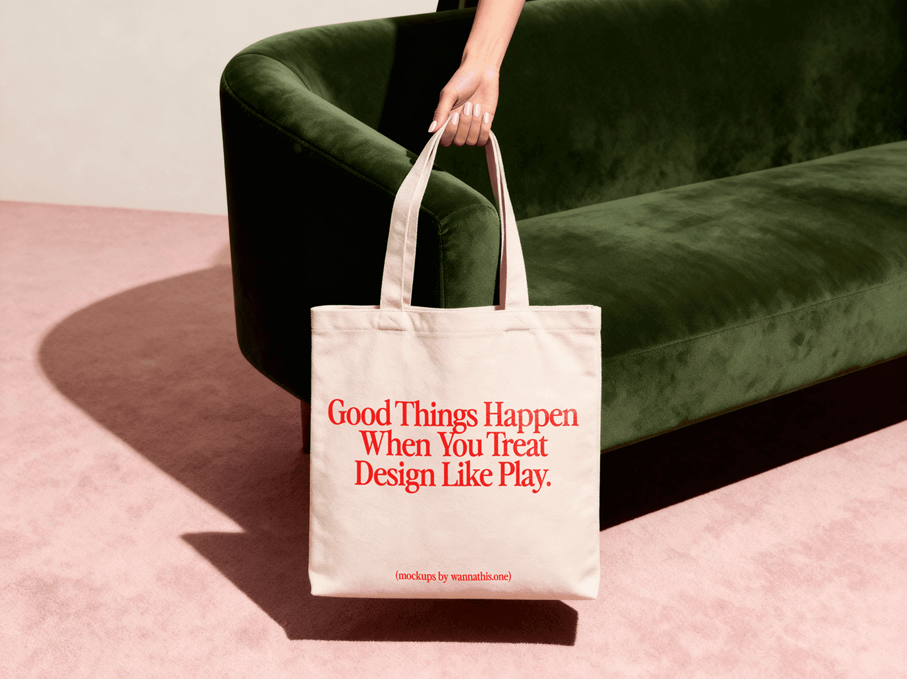 Tote bag mockup hanging from a person's hand next to a sofa