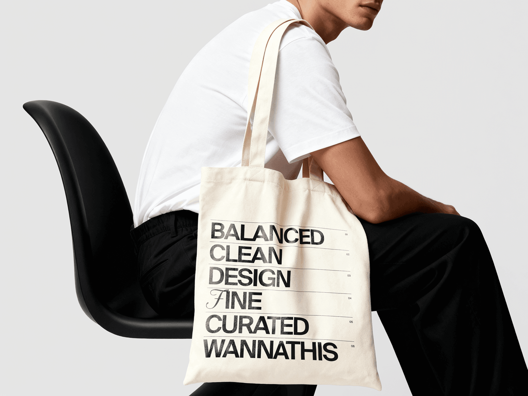 Tote bag mockup placed on a person's shoulder while seated in a chair