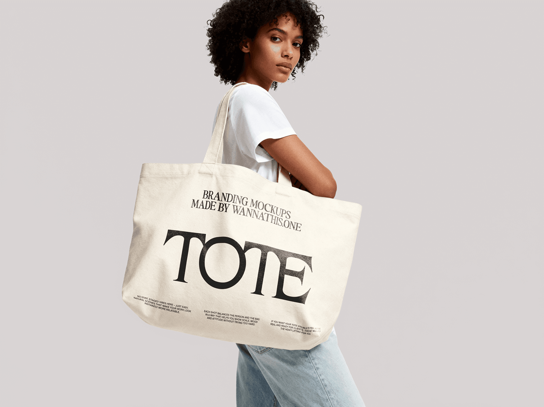 Tote bag mockup held by a standing model in a minimal studio