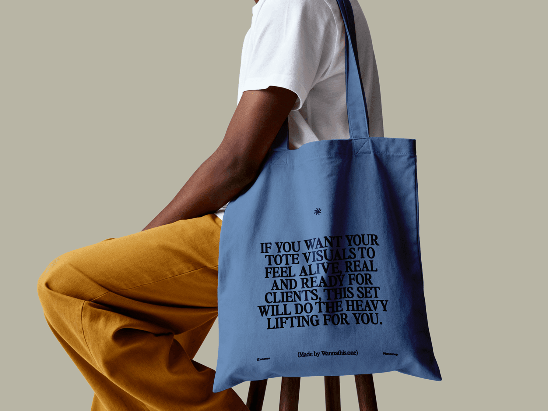 Tote bag mockup hanging from the shoulder of a seated model