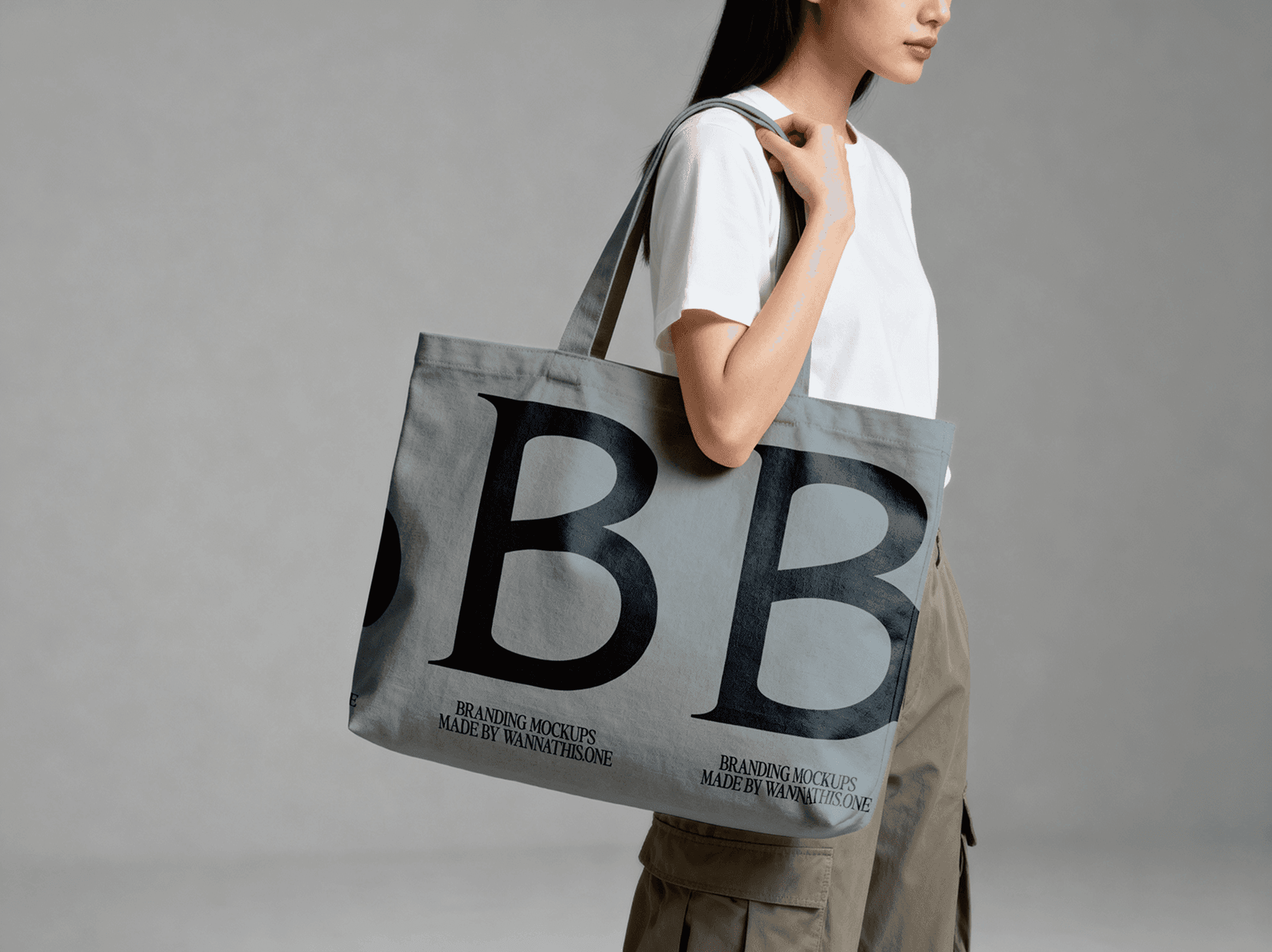 Large tote bag mockup carried by a standing model in studio