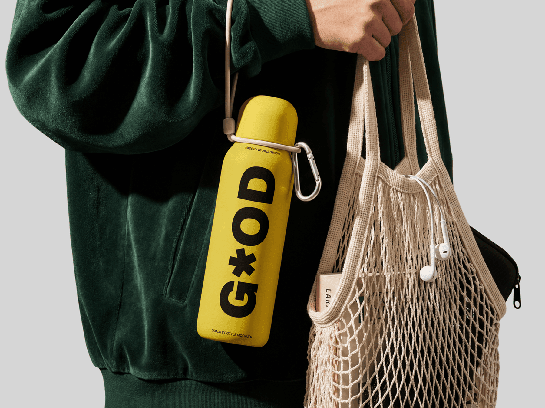 Travel bottle mockup clipped to a refined tote bag with a carabiner accessory in a sustainable lifestyle scene