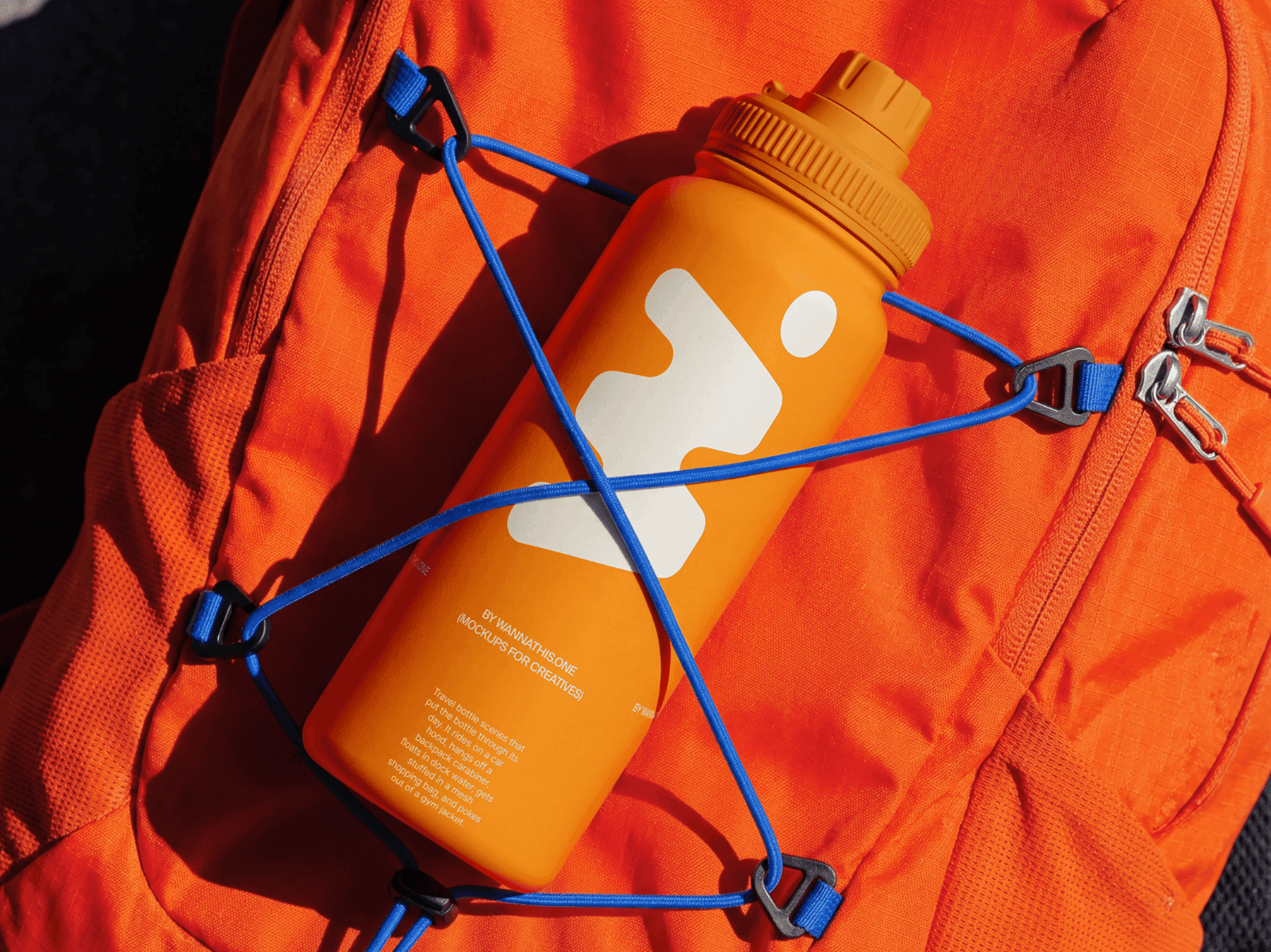 Travel bottle mockup clipped to a hiking backpack strap in a refined outdoor adventure lifestyle scene