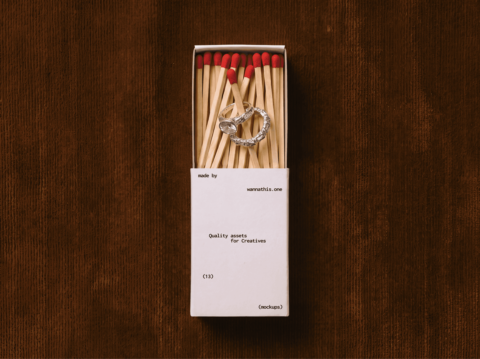 Open vintage matchbox full of matches with a few rings resting on top