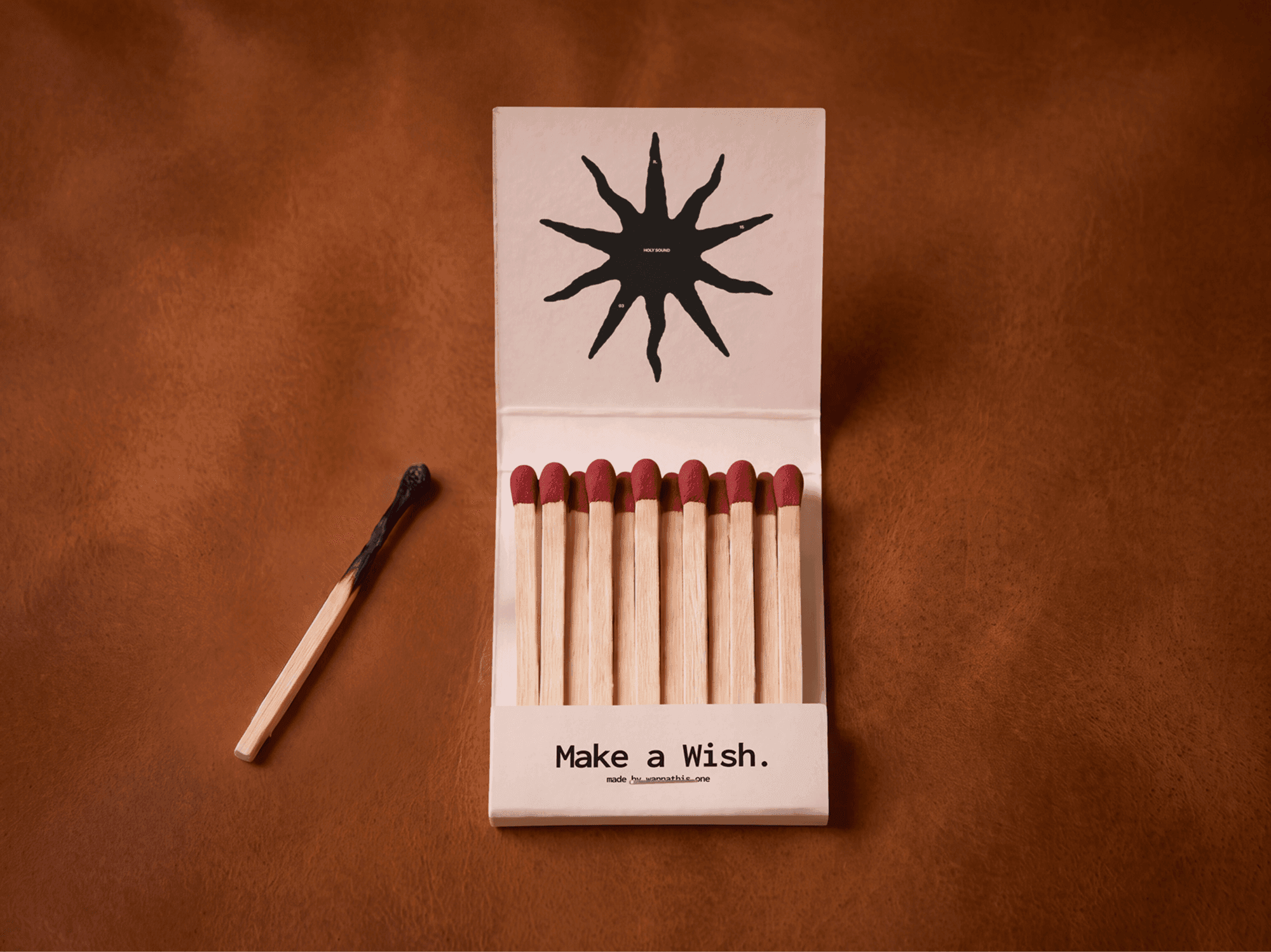 Open vintage matchbox full of matches with a single spent match lying beside it