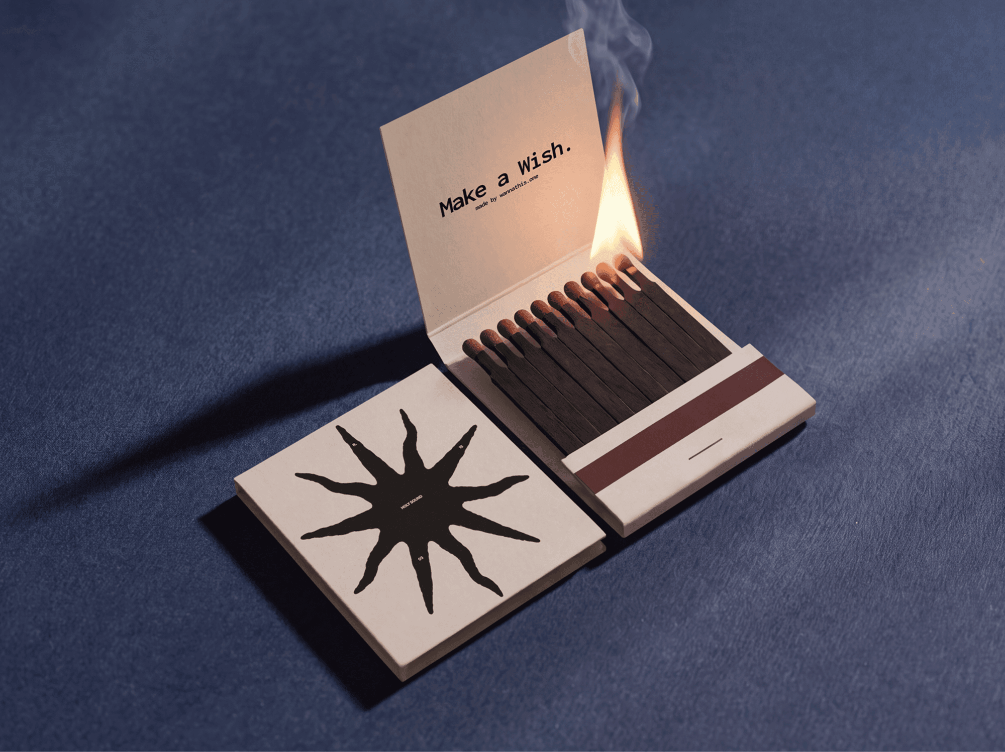 Open vintage matchbox with matches alight beside its separate outer sleeve