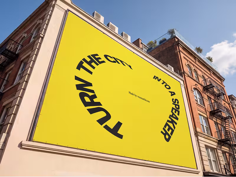 Billboard mounted on the side of an older stone building seen from a low angle
