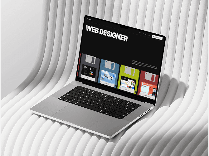 Workdesk Framer portfolio template on a MacBook against a wavy white wall, bold Web Designer hero with retro floppy disk cards, a template for web designers